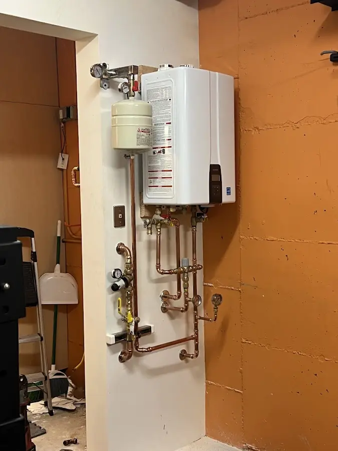 Plumbing technician inspecting water heater connections in Marinette